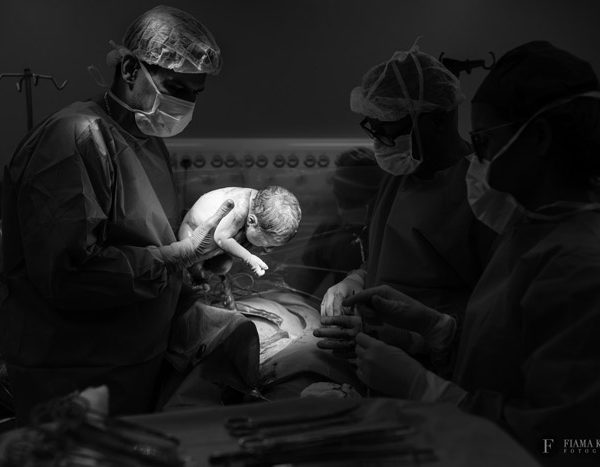 Momento em que o bebê nasceu sendo registrado pela fotógrafa