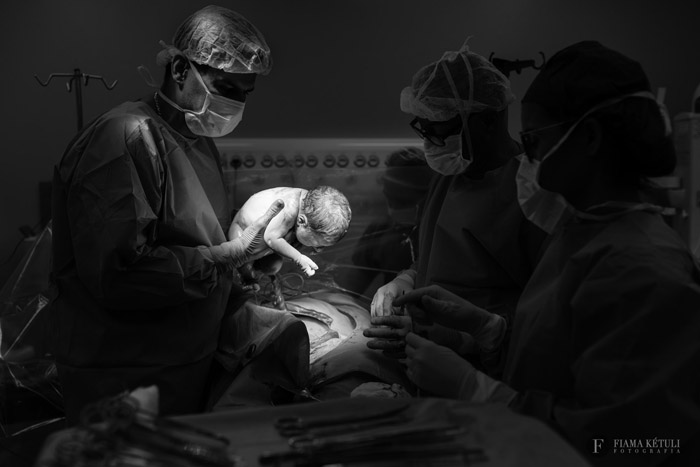 Momento em que o bebê nasceu sendo registrado pela fotógrafa